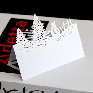 Detail of 3D laser cut white Christmas snowman and tree pop-up card with blank space