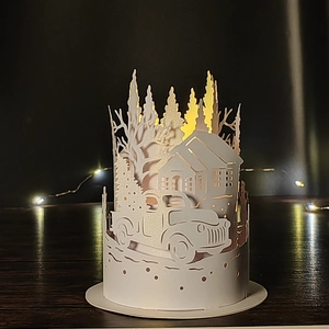 White paper cutout lantern with vintage truck and pine tree design and warm LED light