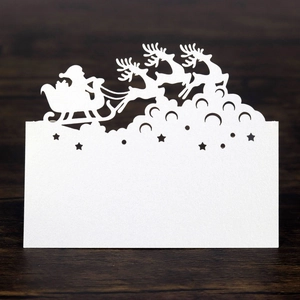 Detailed laser-cut white Christmas table card featuring reindeer and Santa Claus silhouette