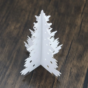 Detailed view of white 3D laser-cut paper Christmas tree with hollow circular patterns