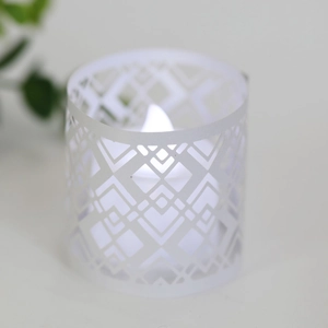 Detail of laser-cut geometric hollow lampshade with warm LED candle light inside