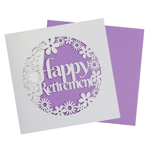 Macro shot of laser-cut Happy Retirement card with white glitter and purple background