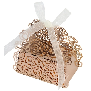 Macro view of laser-cut rose gold wedding favor box with elegant white organza ribbon