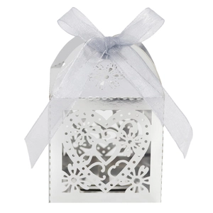 Detail of silver laser-cut heart candy box with light blue ribbon for wedding favors