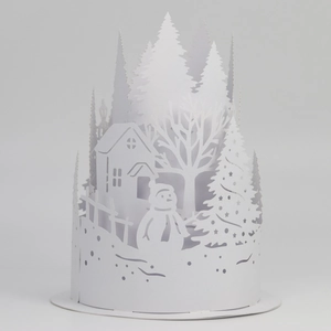 Macro detail of white paper-cut lantern featuring a snowy winter forest house and snowman