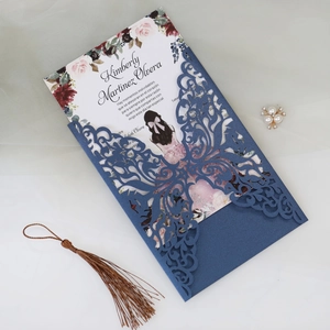 Detail of laser-cut pearl paper invitation with navy blue shell and floral inner card