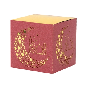 Detail of red square gift box with gold laser-cut moon and mosque patterns for Ramadan