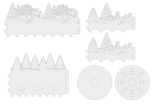 Flat lay of DIY white paper lampshade parts with laser-cut winter snowman and tree scenes