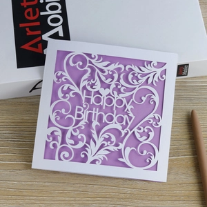 Laser cut birthday card featuring purple insert and Happy Birthday hollow design on wood