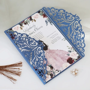 Macro shot of laser-cut navy wedding invitation with floral insert and silk background