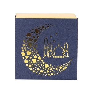 Detail of laser-cut moon and mosque pattern on a blue square paper light box