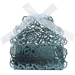 Close-up of laser-cut teal gift box with rose patterns and a light blue organza ribbon bow