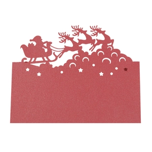 Detail of red laser-cut Christmas table card featuring reindeer and Santa Claus silhouette