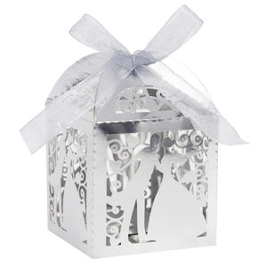 Macro detail of silver laser-cut wedding favor box featuring bride and groom silhouette