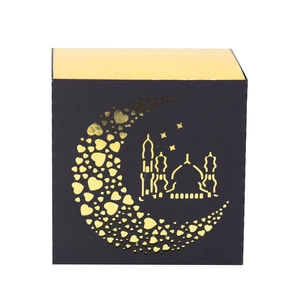 Close-up of black and gold Eid gift box with crescent moon and mosque cutouts