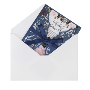 Detailed laser-cut navy blue floral invitation set with pink card and satin ribbon bow