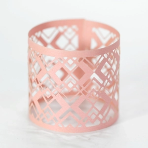 Close-up of pink laser-cut hollow paper lampshade with elegant geometric pattern