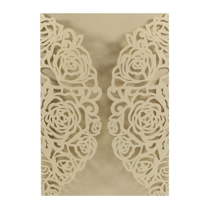 Laser-cut champagne gold pearlescent paper invitation cover with intricate rose floral patterns