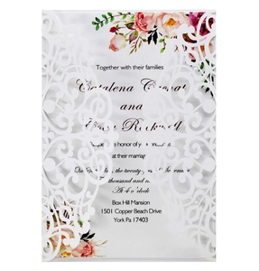 Macro view of laser-cut lace invitation with elegant floral patterns and text details
