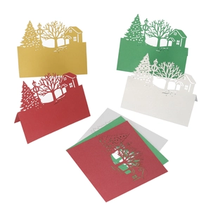Macro detail of laser-cut Christmas house and tree table cards in pearl paper