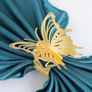 Elegant gold hollow butterfly napkin ring on green satin fabric for wedding decoration