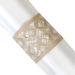 Close-up of laser-cut gold napkin ring featuring intricate geometric diamond patterns