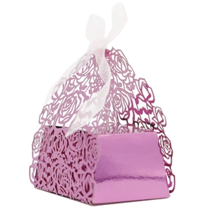 Macro detail of laser-cut rose patterns on purple favor box with white ribbon bow