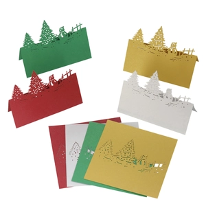 Detailed laser-cut Christmas place cards featuring snowman and tree in metallic cardstock