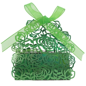 Detail of green laser-cut floral candy box with an organza ribbon bow for weddings