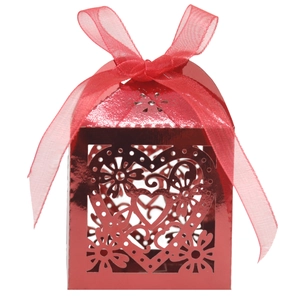 Detail of red laser-cut heart candy box with elegant floral patterns and ribbon bow