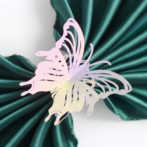 Detailed laser-cut iridescent butterfly napkin ring shown on dark green satin fabric