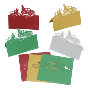 Laser-cut Christmas table cards with snowman and truck patterns in assorted colors