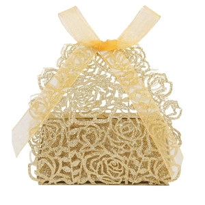 Close-up of golden glitter laser-cut rose favor box with champagne organza ribbon bow