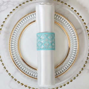Close-up of laser-cut sky blue napkin ring with geometric pattern on a white napkin