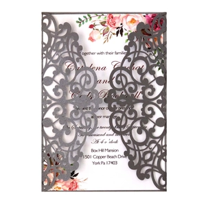 Detail of laser-cut glitter wedding invitation with watercolor floral inner card