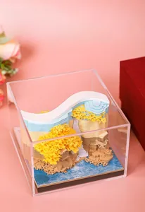 Macro detail of a 3D paper-cut notepad featuring a landscape with tree and acrylic box