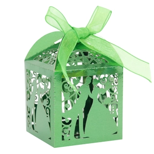 Detail of laser-cut green wedding candy box with heart patterns and organza ribbon bow
