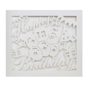 Macro detail of laser-cut 13th birthday card with Happy Birthday hollow patterns