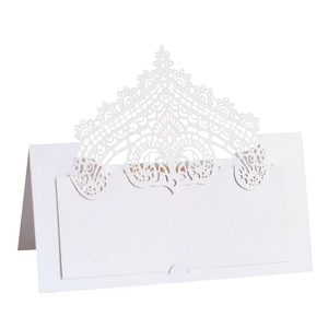 Detailed laser-cut lace design on white paper tent place card for wedding reception