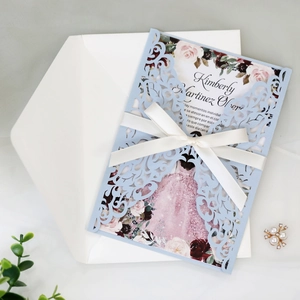 Detail of laser-cut light blue invitation with white satin bow and floral inner page