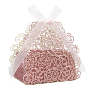 Close-up of laser-cut pink glitter candy box with rose patterns and white organza ribbon