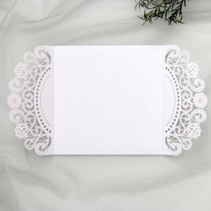 Detail of white laser-cut hollow lace and floral design on an elegant paper wedding invitation