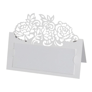 Detail of laser-cut floral white table card with elegant hollow pattern for weddings