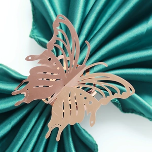 Close-up of rose gold laser-cut butterfly napkin ring on elegant silk fabric