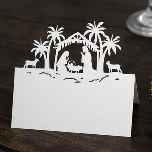 Macro shot of laser-cut Nativity scene place card on elegant dark wood surface