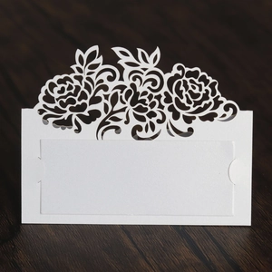 Detail view of laser-cut rose hollow place card with name card slots on dark wood