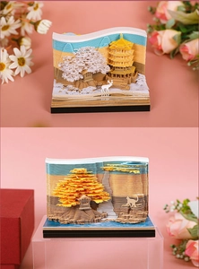 Detailed close-up of a 3D paper-cut notepad showing cherry blossoms and autumn scenes