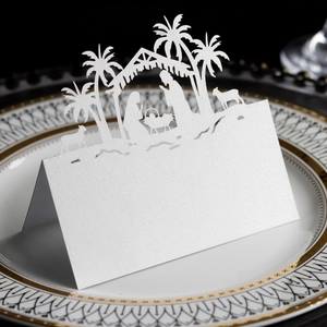 Macro detail of laser-cut Nativity scene on white pearlescent paper table card