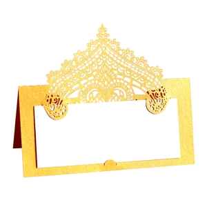 Close-up of golden laser-cut lace table card with crown hollow design and white insert