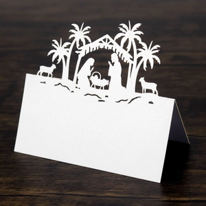 Close-up of laser-cut Nativity scene silhouette on white pearlescent paper table card